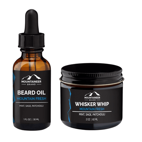 A bottle of Mountain Fresh Beard Oil and a container of Whisker Whip Beard Butter with Mountaineer Brand Products in the background.