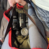 Person holding a Mountaineer Brand Products Gym Bag Kit with personal care products inside for their post-workout routine.