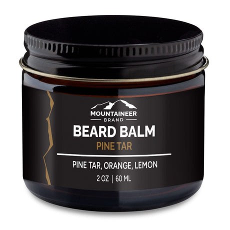 A jar of Mountaineer Brand Products beard balm labeled "pine tar" with scents of natural essential oils, including pine tar, orange, and lemon, containing 2 oz or 60 ml