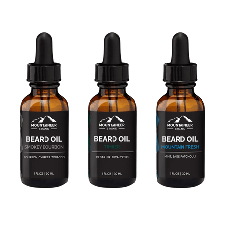Three bottles of premium quality Mountaineer Brand Products beard oil in different scents: smokey bourbon, timber, and mountain fresh.
