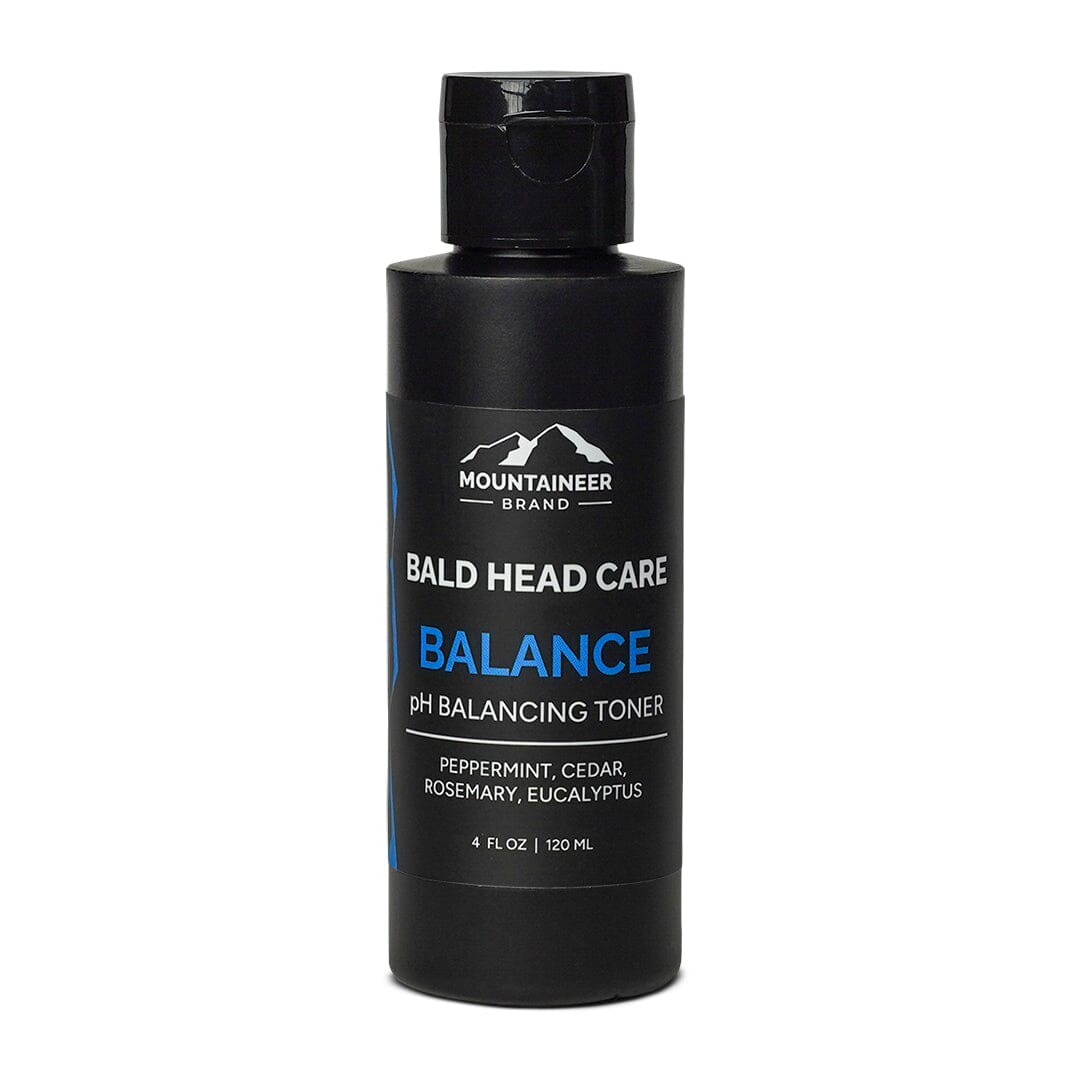 A bottle of Mountaineer Brand Products Bald Head Shine Away PH Balancing Toner with peppermint, cedar, rosemary, and eucalyptus.
