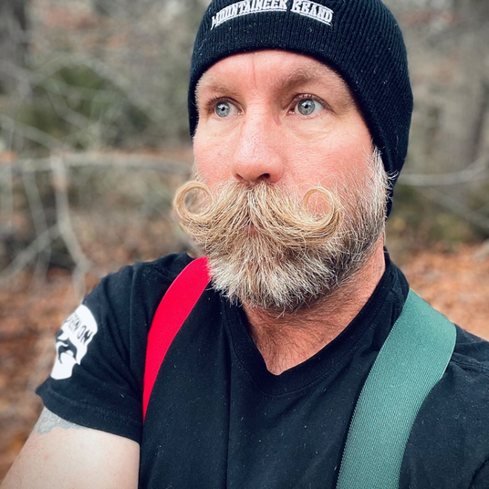 A man sporting an all-natural beanie with a moustache.