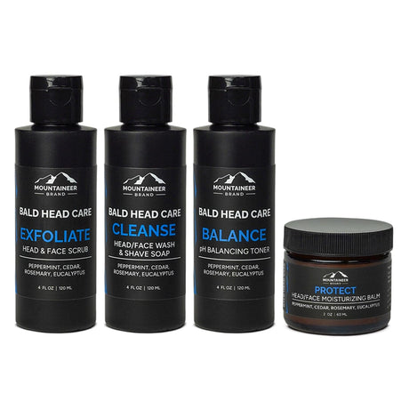 A set of four Mountaineer Brand Products including The Essential Bald Head Care System featuring exfoliating scrub, face wash, balancing toner, and moisturizing balm infused with natural essential oils.