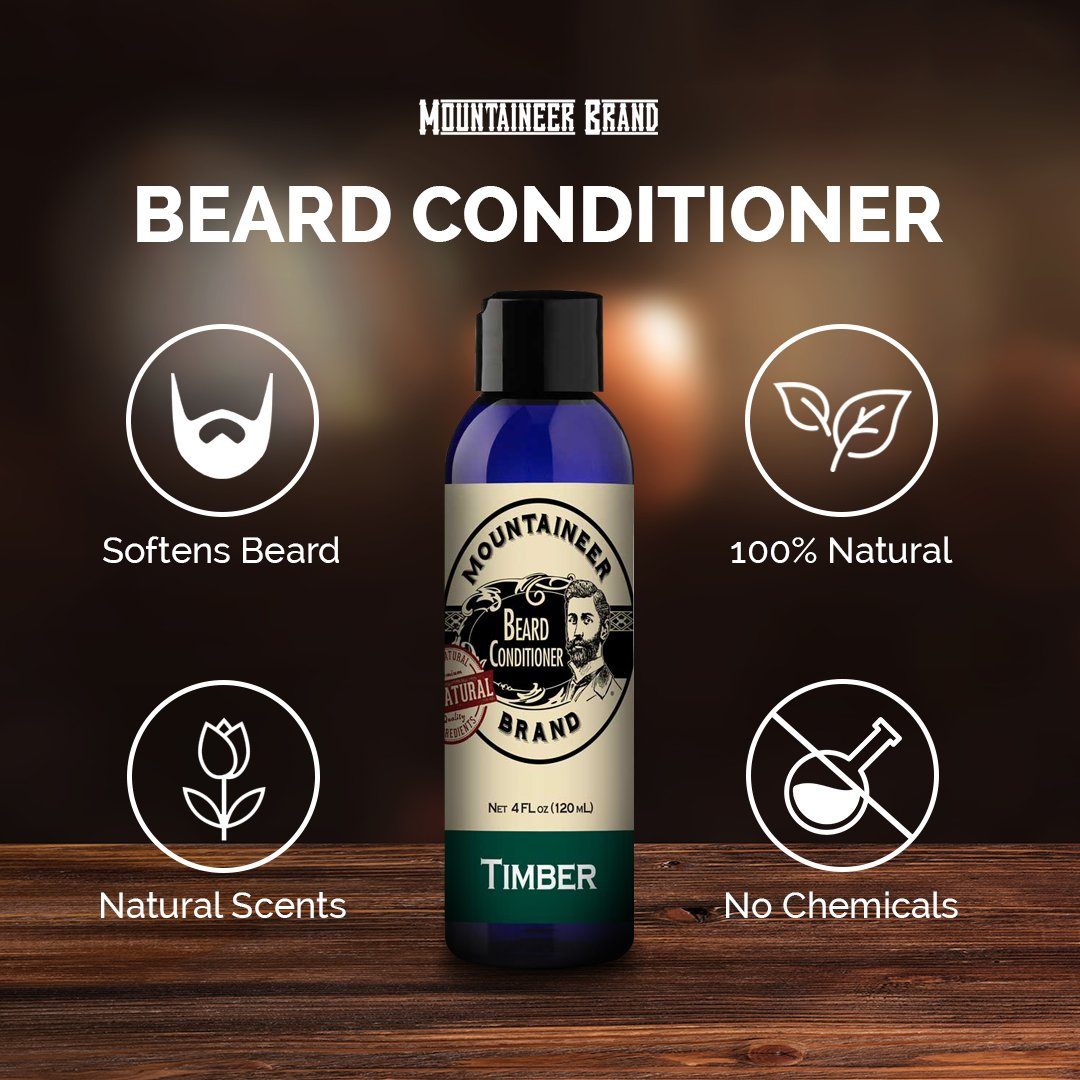 A bottle of Mountaineer Brand Products Natural Beard Conditioner labeled "timber" on a wooden surface, highlighted by icons indicating it is natural, chemical-free, and softens beards.