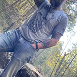 An all-natural, bearded man wearing a Mountaineer Brand Products 100% Organic Beard Man T-Shirt in the woods.